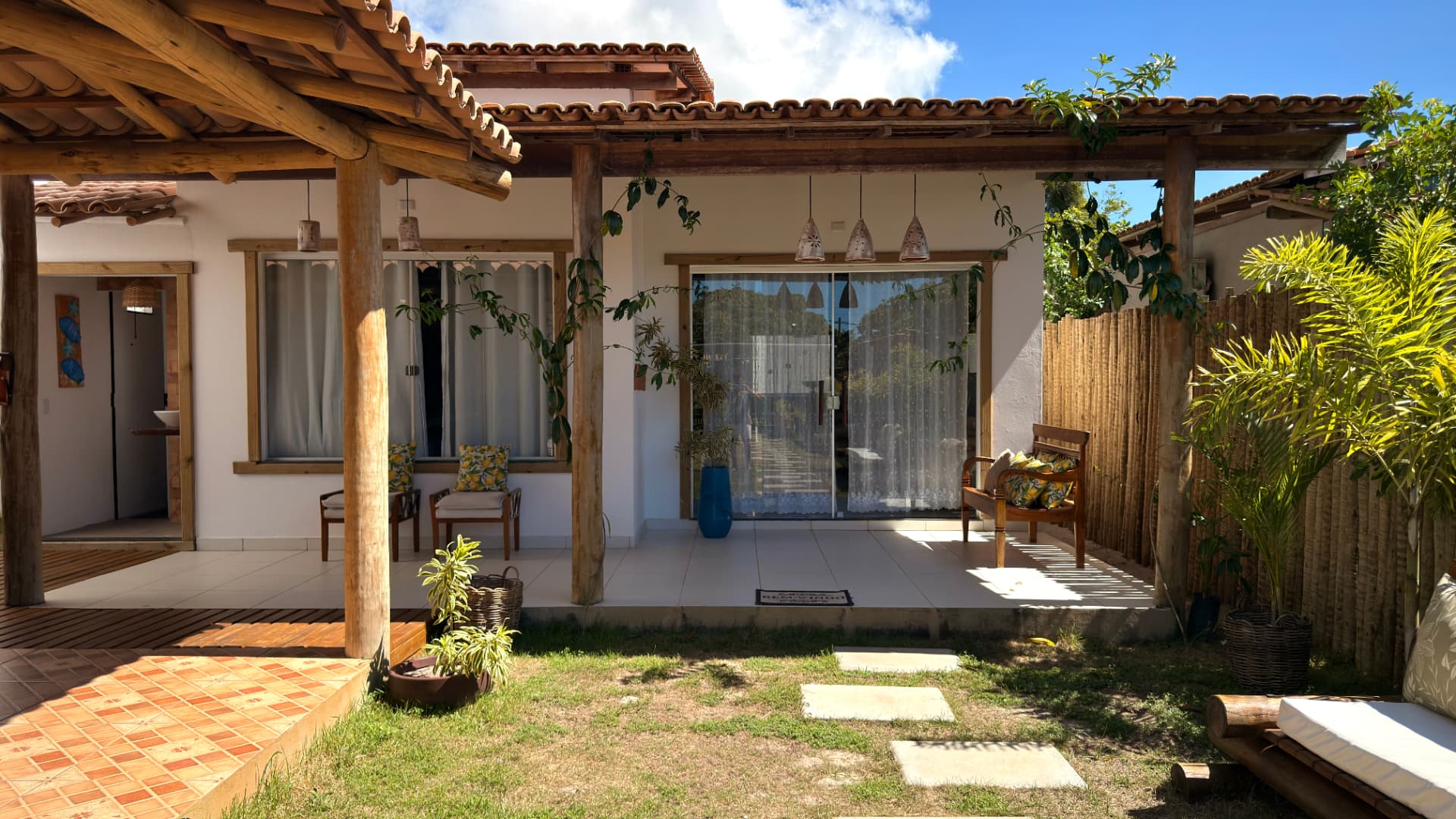 Fachada da Casa Marie com varanda e jardim